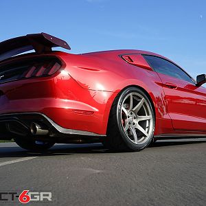 Project 6gr wheels on a Ruby Red Ford Mustang GT Rear Passenger View